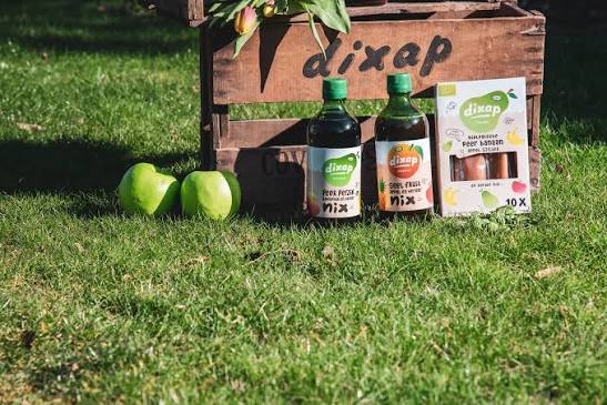 Dixap kist met flessen en appels in het gras